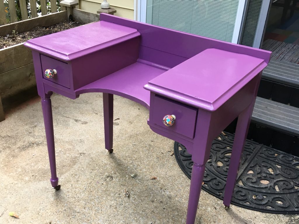 Freshly painted purple vanity with new knobs.